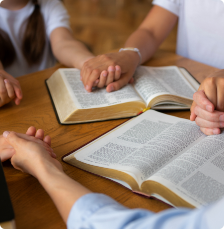 students praying around a Bible